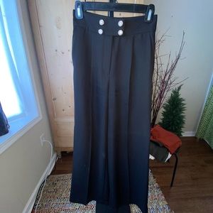 Women’s super high waisted pleated trousers with embellishment buttons.